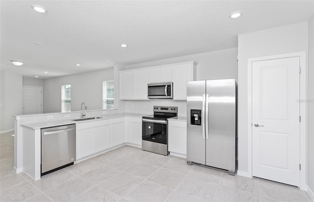 kitchen with white cabinets, a textured ceiling, stainless steel appliances, and sink