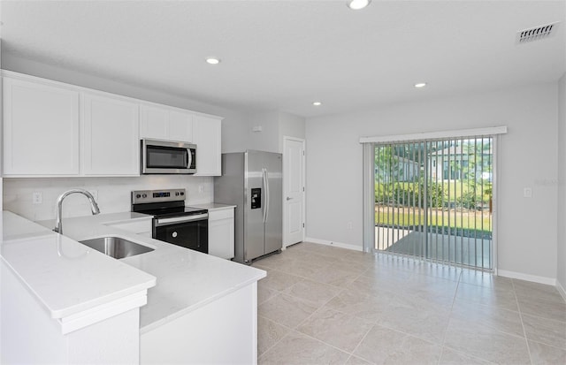 kitchen with white cabinetry, light tile patterned floors, stainless steel appliances, kitchen peninsula, and sink