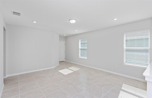 tiled empty room featuring plenty of natural light