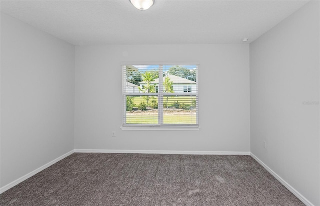 carpeted spare room featuring a textured ceiling