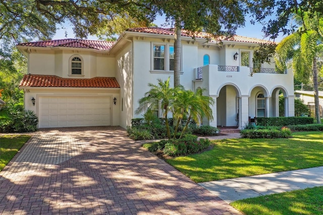 mediterranean / spanish-style home featuring a garage, a balcony, and a front lawn