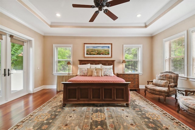 bedroom featuring dark hardwood / wood-style flooring, a tray ceiling, and ornamental molding