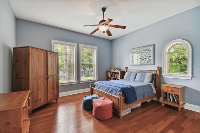 bedroom with multiple windows, dark wood-type flooring, and ceiling fan