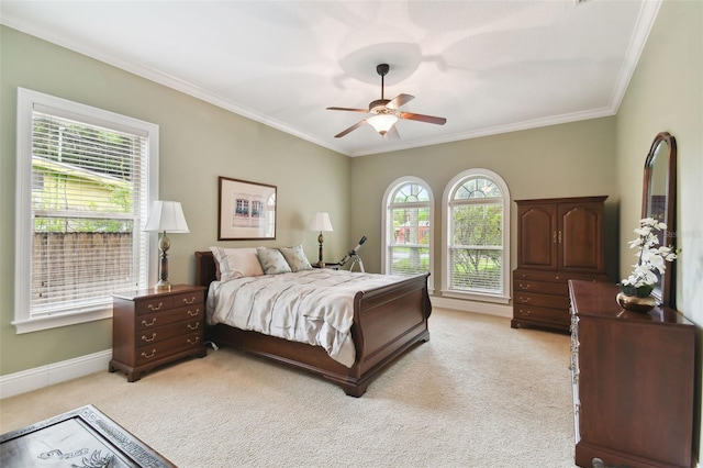 bedroom featuring ornamental molding, light colored carpet, and ceiling fan