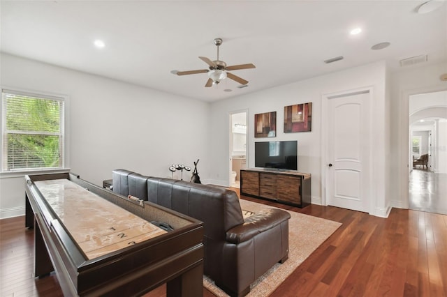 living room with dark wood-type flooring and ceiling fan