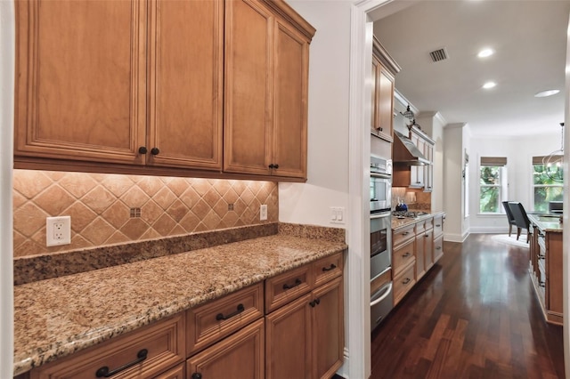 kitchen with light stone counters, dark hardwood / wood-style flooring, tasteful backsplash, and appliances with stainless steel finishes