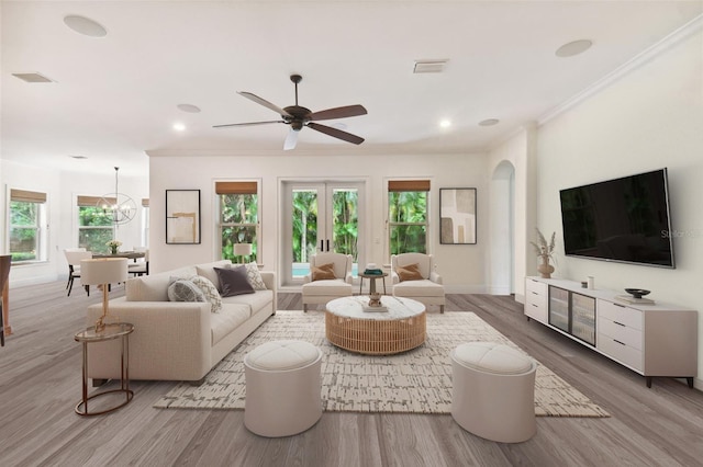 living room with crown molding, ceiling fan with notable chandelier, hardwood / wood-style floors, and french doors