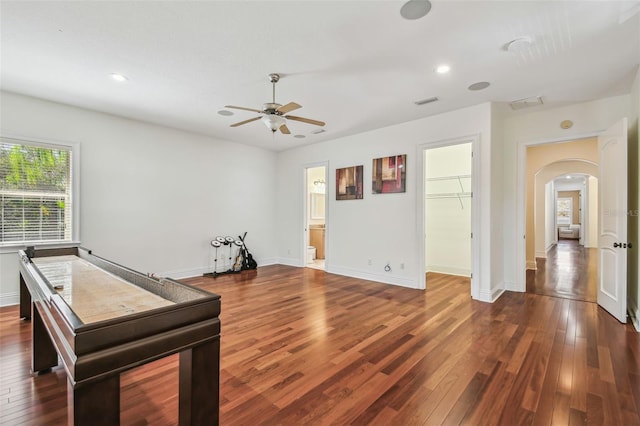 recreation room with arched walkways, recessed lighting, wood-type flooring, and baseboards