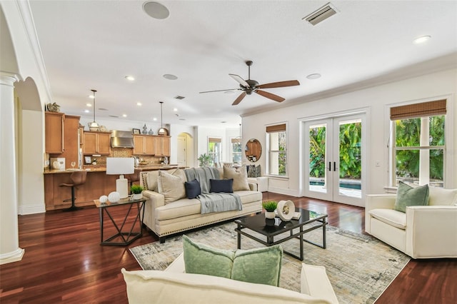 living area with french doors, dark wood finished floors, decorative columns, visible vents, and ornamental molding