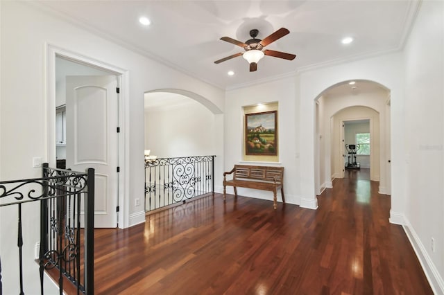 hall with arched walkways, wood finished floors, and an upstairs landing