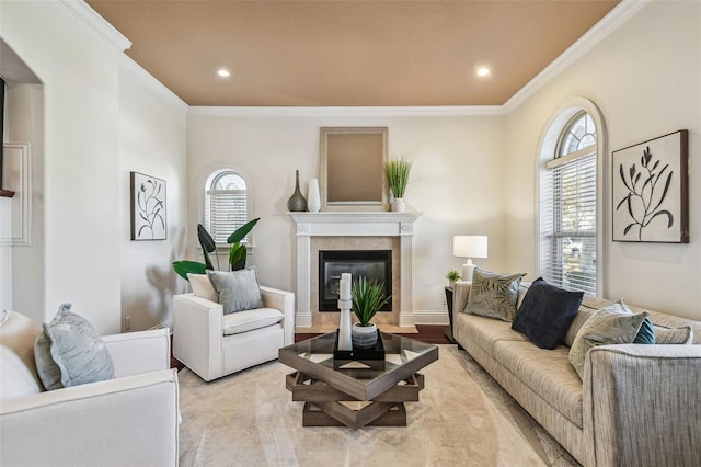 living area featuring crown molding, baseboards, a wealth of natural light, and a glass covered fireplace