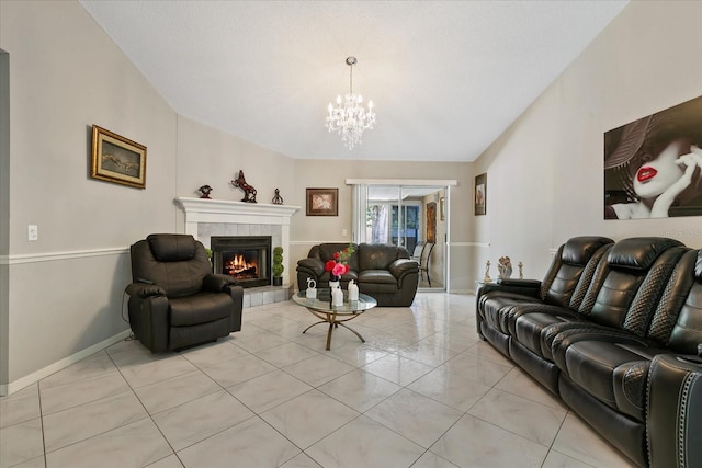 living room with a chandelier, light tile patterned floors, a textured ceiling, and a tiled fireplace