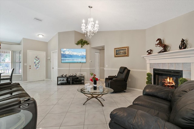 living room featuring a tiled fireplace, light tile patterned flooring, a chandelier, and lofted ceiling