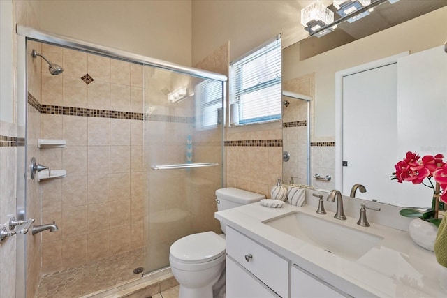 bathroom featuring tile patterned floors, vanity, toilet, and a shower with shower door