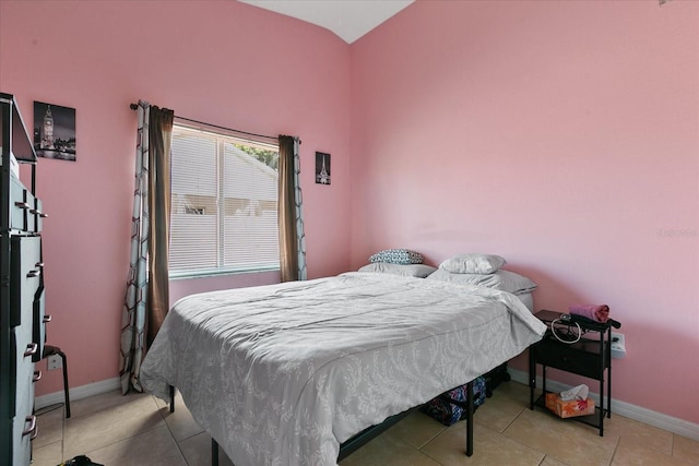 tiled bedroom featuring vaulted ceiling