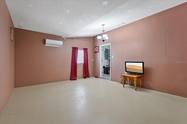 empty room featuring a chandelier, a textured ceiling, concrete floors, and an AC wall unit