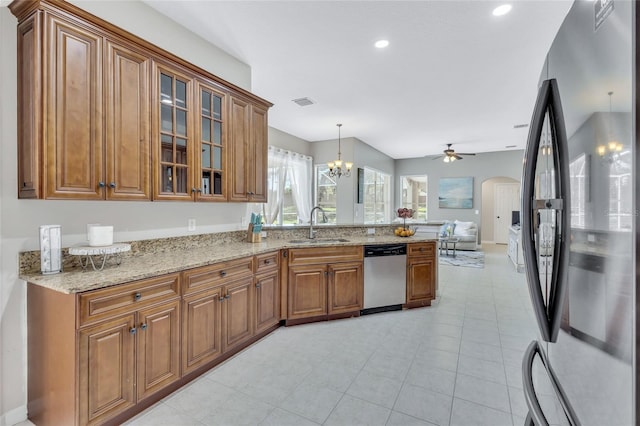 805 Woodcarver Ln, Brandon, FL 33510 - kitchen featuring freestanding refrigerator, dishwasher, a peninsula, brown cabinets, and a ceiling fan