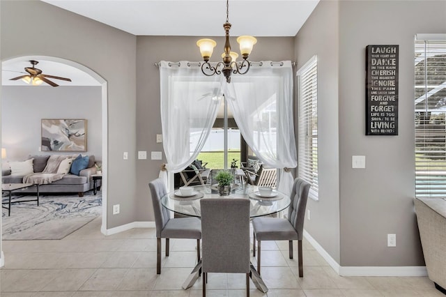 805 Woodcarver Ln, Brandon, FL 33510 - dining area featuring a chandelier, a ceiling fan, arched walkways, and light tile patterned floors