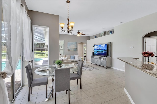 805 Woodcarver Ln, Brandon, FL 33510 - dining area with arched walkways, a chandelier, light tile patterned flooring, and ceiling fan
