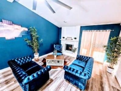 living room featuring wood-type flooring and ceiling fan