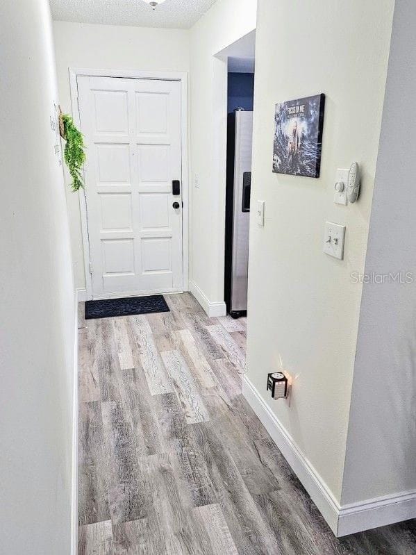 hall with a textured ceiling and hardwood / wood-style floors