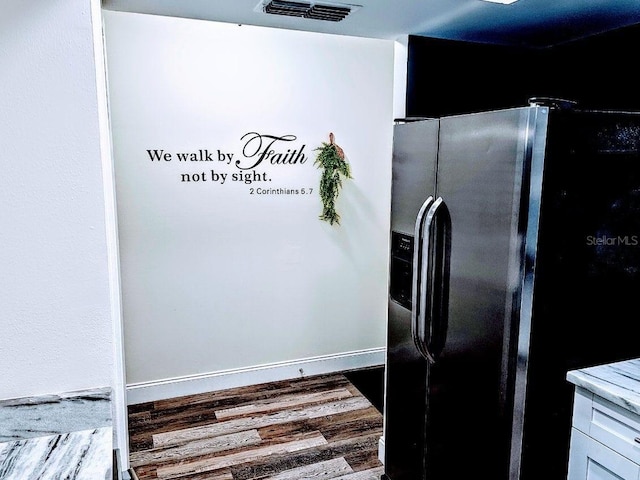 kitchen with hardwood / wood-style floors, stainless steel refrigerator with ice dispenser, and white cabinetry