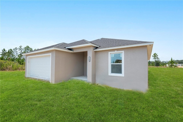 view of front of property featuring a front yard and a garage