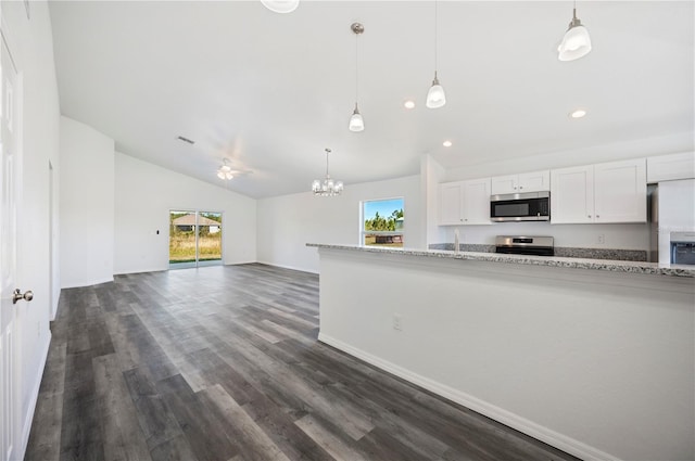 kitchen featuring dark wood-style flooring, decorative light fixtures, stainless steel appliances, white cabinets, and vaulted ceiling