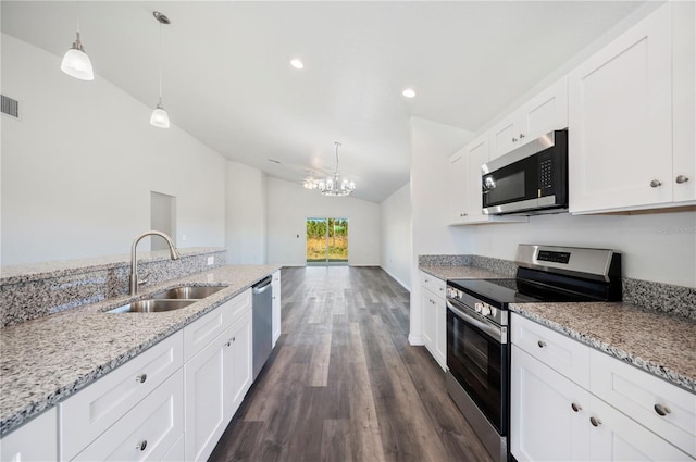 kitchen with a sink, white cabinetry, vaulted ceiling, appliances with stainless steel finishes, and light stone countertops