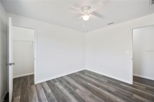 spare room with baseboards, visible vents, and wood finished floors