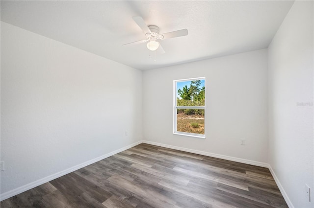 empty room featuring dark wood-type flooring, baseboards, and a ceiling fan