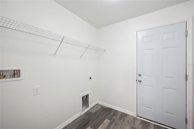 clothes washing area featuring hookup for an electric dryer, laundry area, dark wood-type flooring, washer hookup, and baseboards