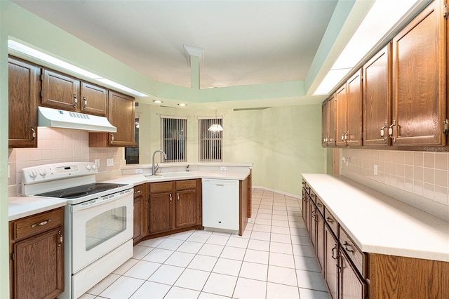 kitchen featuring kitchen peninsula, decorative backsplash, white appliances, sink, and light tile patterned floors