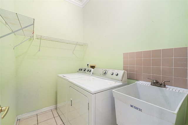 laundry room featuring light tile patterned flooring, separate washer and dryer, ornamental molding, and sink