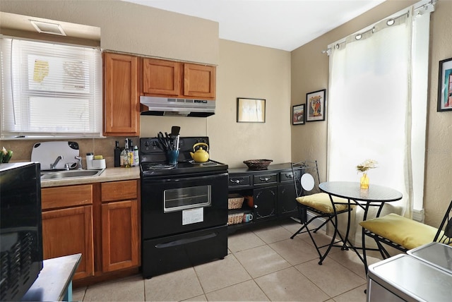 kitchen featuring light tile patterned floors, sink, and black / electric stove