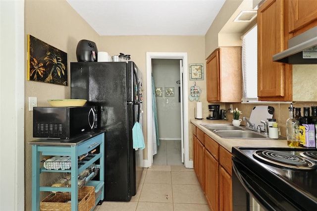 kitchen with black appliances, light tile patterned floors, sink, and extractor fan