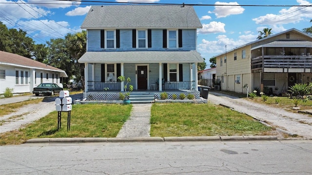 bungalow-style house featuring covered porch and a front yard