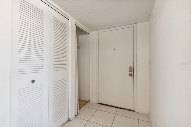 interior space featuring light tile patterned floors and a textured ceiling