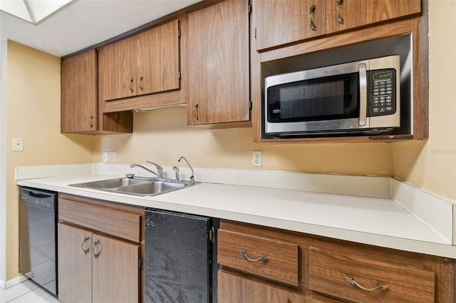 kitchen with sink, light tile patterned floors, and black dishwasher