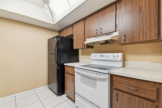 kitchen with white electric range, black fridge, and light tile patterned floors