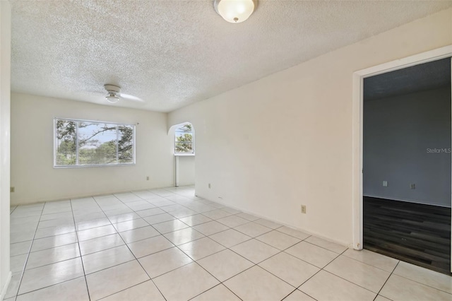 tiled spare room with ceiling fan and a textured ceiling