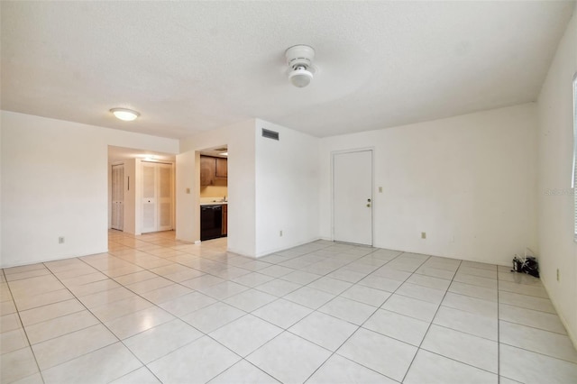 empty room with light tile patterned floors and a textured ceiling