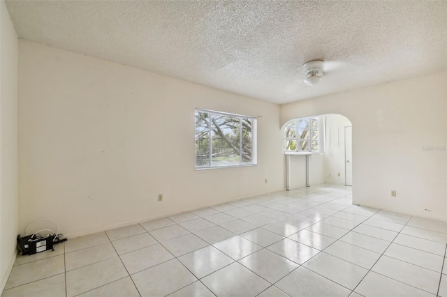 empty room featuring light tile patterned floors and a textured ceiling