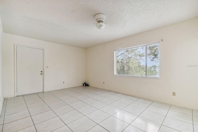 unfurnished room featuring light tile patterned flooring and a textured ceiling