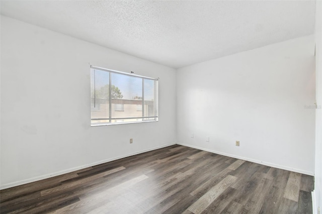 spare room with dark hardwood / wood-style flooring and a textured ceiling