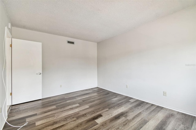 unfurnished room featuring a textured ceiling and dark wood-type flooring