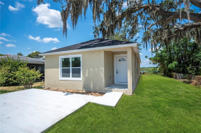 view of front of property with a patio area and a front lawn