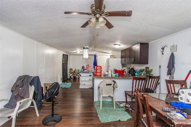 dining space featuring lofted ceiling, ceiling fan, dark wood-type flooring, and a textured ceiling