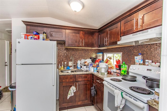 kitchen featuring white appliances, light stone countertops, vaulted ceiling, and light tile patterned floors