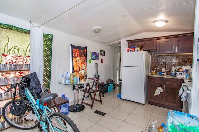 kitchen with lofted ceiling, sink, white appliances, backsplash, and dark brown cabinetry